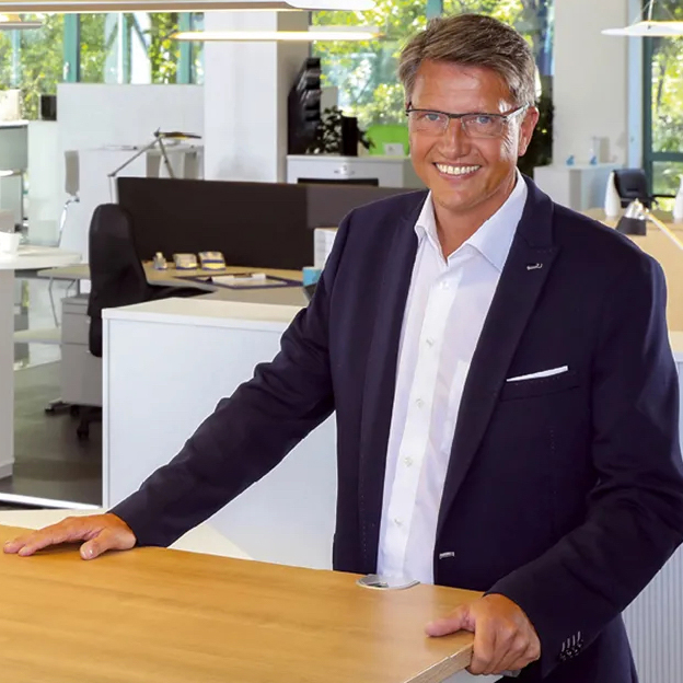 DELTA-V Geschäftsführer Guido Hensel steht an einem Sitz-Steh-Schreibtisch.