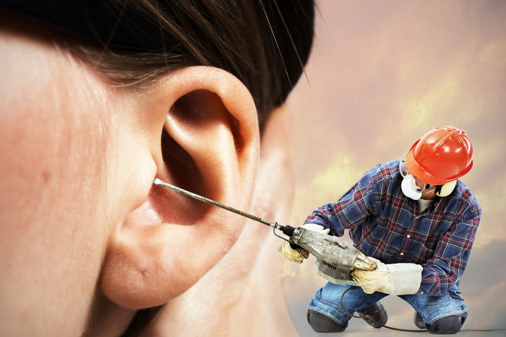 Detailbild eines Ohres, vor dem ein Mann mit Bauhelm sitzt und einen Bohrhammer ins Ohr hält.