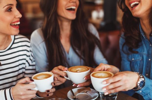 Drei Freundinnen sitzen im Café und trinken Kaffee
